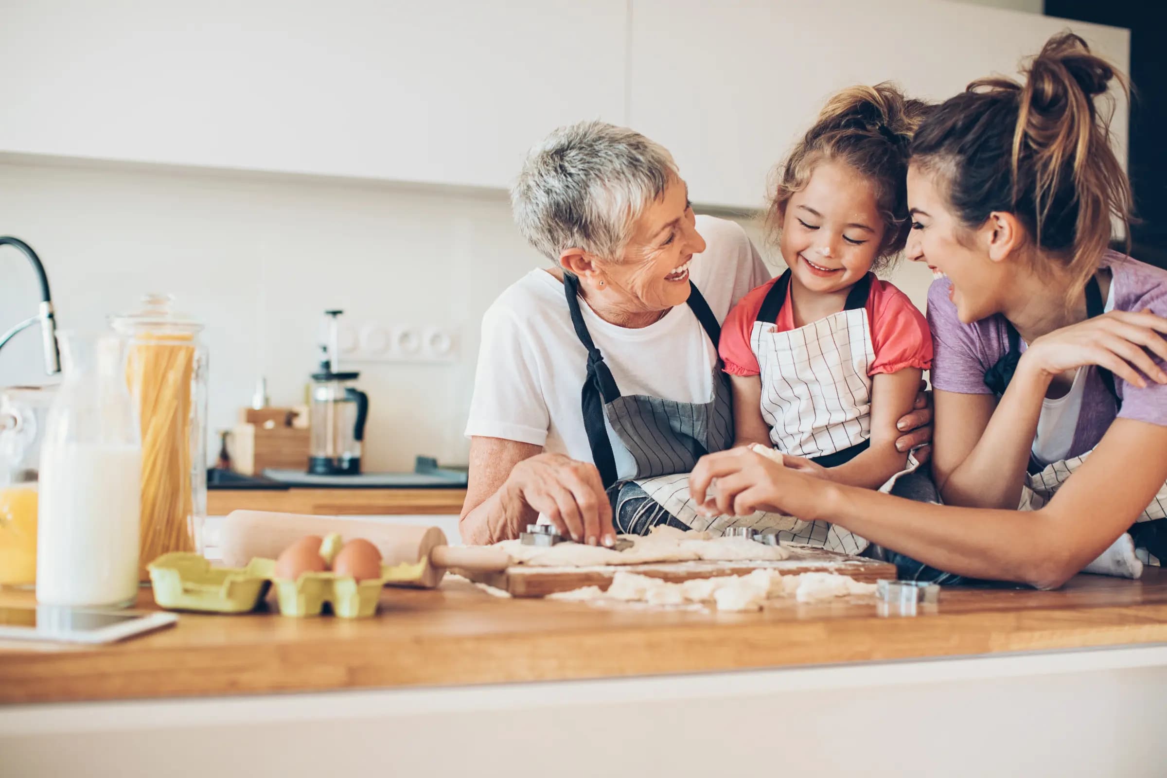 A grandmother, mother, and child baking together