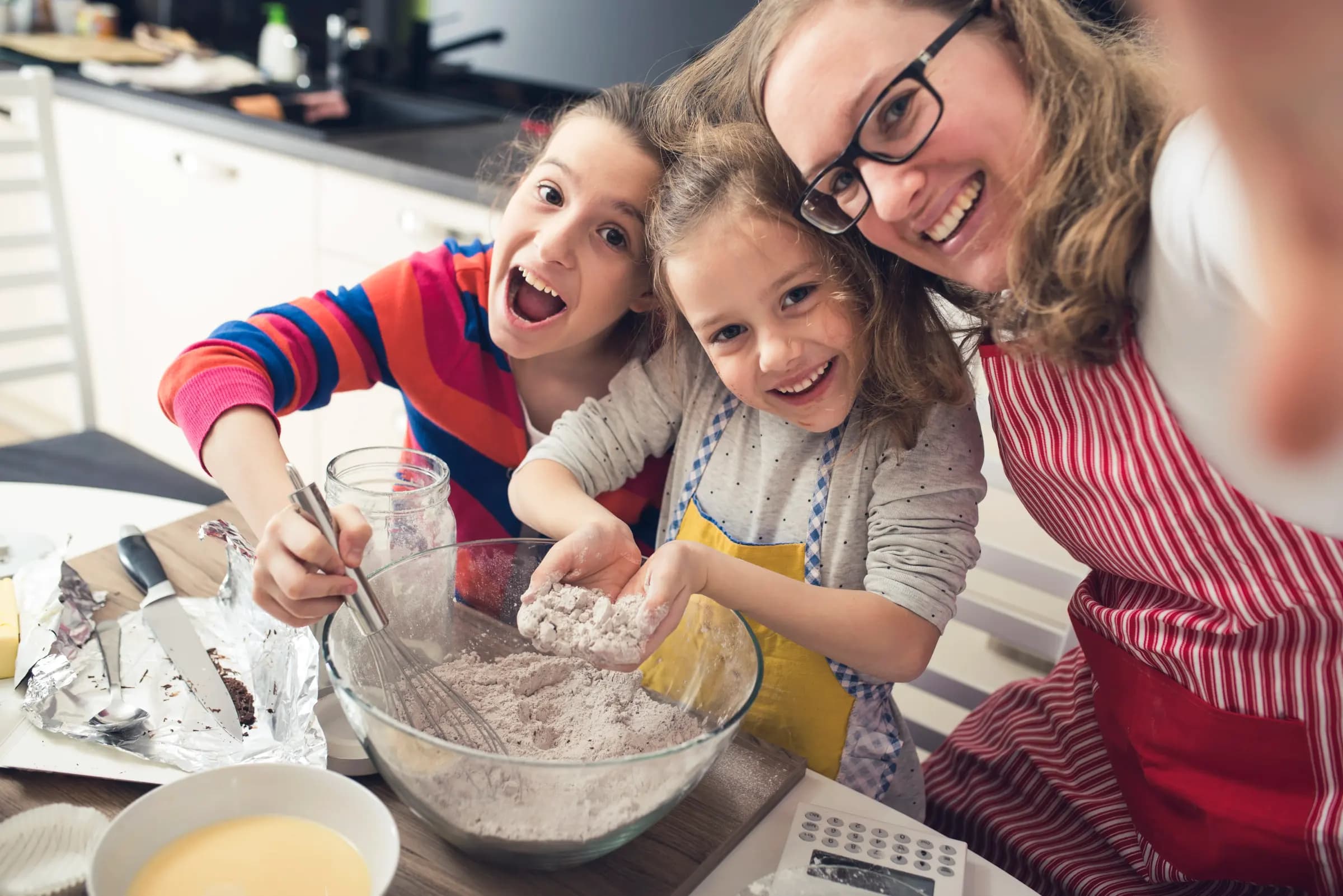 A mother and her two daughters baking together